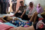 Kapolresta Medan, Kombes Pol Mardiaz Kusin Dwihananto (kiri) didampingi isteri yang juga Ketua Bhayangkari Medan R.A.Irwanda Anatasha (kanan) melihat kondisi Della Amanda (12) yang mengalami pembengkakan dikelopak mata, ketika menjenguk dan memberikan bantuan dikediamannya di Jalan Denai Gang Rukun, Medan, Sumatera Utara, Senin (20/6). Della Amanda sejak dua tahun terakhir mengalami pembengkakan dikelopak mata kiri dan berpangaruh terhadap kondisi tubuh yang terus melemah. ANTARA SUMUT/Irsan Mulyadi/16