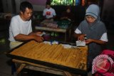 Sejumlah pekerja mengemas makanan ringan ting-ting gepuk di Sidomukti, Salatiga, Jawa Tengah, Kamis (16/6). Sebulan menjelang Lebaran 2016, Industri makanan ringan khas Salatiga ting-ting gepuk yang terbuat dari bahan dasar kacang dan gula mengalami peningkatan produksi dari 4200 biji menjadi 7500 biji per hari, yang dijual ke sejumlah daerah seperti Yogyakarta, Jakarta, Jambi, Surabaya, Bandung, Riau, dengan harga Rp 310 ribu per besek (isi 60 biji). ANTARAFOTO/ Aloysius Jarot Nugroho/ama/16.