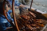 Penjual sate ayam asal Ponorogo, Jawa Timur membakar sate ayam di Kota Madiun, Jawa Timur, Senin (20/6). Sate ayam Ponorogo dikenal memiliki keunggulan kelezatan rasa dan potongan dagingnya yang besar dijual dengan harga Rp24.000 per 10 tusuk. Antara Jatim/Foto/Siswowidodo/zk/16
