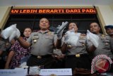 Kapolda Jambi Brigjen Pol. Yazid Fanani (kedua kiri) dan Wakapolda Kombes Pol. Nugroho Ajdi (ketiga kanan) menunjukkan barang bukti sabu-sabu dan sepucuk senjata api jenis FN milik tersangka saat rilis kasus narkoba di Mapolda Jambi, Kamis (16/6). Aparat Kepolisian setempat berhasil menangkap enam tersangka yang diduga anggota sindikat narkoba internasional dengan barang bukti 1,4 kilogram sabu-sabu asal Tiongkok senilai Rp3,1 miliar, uang tunai Rp33,5 juta, emas 68,97 gram, sepucuk senjata api jenis FN, 42 butir peluru, timbangan digital, dan empat unit telepon genggam. ANTARA FOTO/Wahdi Septiawan/pd/16.