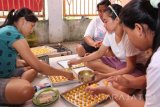 Sejumlah mantan Tenaga Kerja Wanita (TKW) menyelesaikan pembuatan berbagai jenis kue di Cluring, Banyuwangi, Jawa Timur, Selasa (21/6).  Puluhan eks TKW tersebut, membentuk komunitas Keluarga Migran Indonesia (kami) untuk memproduksi makanan ringan yang selanjutnya di ekspor ke beberapa Negara tempat dimana mereka bekerja sebelumya seperti Singapura, Taiwan, dan Hongkong. Antara Jatim/Budi Candra Setya/zk/16.