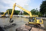 Pekerja dengan alat berat mengeruk endapan sampah bercampur lumpur di Sungai Kalimas, Surabaya, Jawa Timur, Rabu (22/6). Pengerukan tersebut untuk menormalkan kedalaman sungai sehingga aliran air menjadi semakin lancar. Antara Jatim/M Risyal Hidayat/zk/16