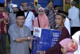 Gubernur Kepulauan Bangka Belitung Rustam Effendi menyerahkan bantuan kepada pengurus Masjid Nurul Islam II pada rangkaian Safari Ramadhan pertama di Pulau Belitung, Selasa (20/6/2016). (Foto Antara/ Elza)