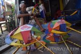 Waris Siswoyo (71) menyelesaikan pembuatan lampion takbiran di Desa Ploso Geneng, Jombang, Jawa Timur, Kamis (23/6). Menjelang lebaran, perajin sudah mengerjakan pesanan sekitar 1.300 lampion takbiran berbagai bentuk dengan gambar tokoh kartun berbahan dasar bambu dan kertas minyak, dijual Rp 10 ribu perbuah. Antara Jatim/Syaiful Arif/zk/16