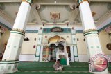 Seorang bocah membaca Alquran di Masjid Hunto, Kota Gorontalo. Masjid Hunto Sultan Amai merupakan pusat perkumpulan Islam yang dibangun pada tahun 1495 Masehi oleh Sultan Amai dan telah dijadikan cagar budaya oleh Balai Pelestarian Cagar Budaya (BPCB). (ANTARA FOTO/Adiwinata Solihin)