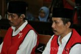 Terdakwa kasus pembunuhan aktifis tambang pasir Lumajang Salim Kancil dan penganiayaan Tosan, Kepala Desa Selok Awar-Awar (non aktif) Hariyono (kanan) dan Mad Dasir (kedua kanan) memasuki ruang sidang di Pengadilan Negeri Surabaya, Jawa Timur, Kamis (23/6). Dalam sidang dengan agenda pembacaan putusan (vonis) majelis hakim menjatuhkan hukuman 20 tahun penjara kepada kedua terdakwa. Antara Jatim/Didik Suhartono/zk/16