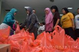 Warga membawa paket sembako saat kegiatan pasar murah PT Perusahaan Gas Negara (PGN) di Kelurahan Wates, Magersari, Mojokerto, Jawa Timur, Jumat (24/6). Pasar murah yang digelar PT Perusahaan Gas Negara(PGN) di 8 daerah secara serentak itu merupakan bagian dari Program BUMN Hadir Untuk Negeri. Dalam pasar murah disediakan total 10 ribu paket sembako senilai Rp 1,5 miliar berisi 10 kg beras, 2 liter minyak goreng, dan 2 kg gula pasir senilai Rp 150 ribu tapi hanya dijual dengan Rp 25 ribu per paket. Antara Jatim/Syaiful Arif/zk/16