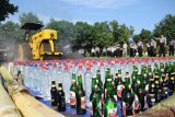 Alat berat melindas minuman keras saat pemusnahan barang bukti hasil operasi camer semeru di Polres Jombang, Jawa Timur, Sabtu (25/6). Jajaran Polres Jombang berhasil mengamanakan 57 tersangka hasil operasi camer semeru selama 11 hari, dengan barang bukti yang berhasil disita diantaranya handak/mercok sebanyak 2 ribu buah jenis mercon, uang judi senilai Rp 4,3 juta, narkotika sebanyak 39 ribu pil dobel L dan miras sebanyak 5 ribu liter. Antara Jatim/Syaiful Arif/zk/16