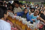 Warga antre menukarkan kupon bazar untuk membeli kebutuhan pokok murah di bulan puasa saat dibukanya bazar rakyat di Denpasar, Bali, Senin (27/6). Bazar yang digelar oleh Kodam IX Udayana tersebut untuk mempermudah warga memperoleh kebutuhan pokok dengan harga murah di tengah meningkatnya harga barang menjelang Idul Fitri 1437 H. ANTARA FOTO/Nyoman Budhiana/i018/2016.