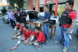 Polisi menunjukan tersangka serta barang bukti kejahatannya saat ungkap kasus pembobolan rumah di Mapolrestabes Surabaya, Jawa Timur, Minggu (26/6). Satreskrim Polrestabes Surabaya menangkap empat tersangka yaitu  AR, DBR, J dan P atas kasus dugaan pembobolan rumah yang disinyalir di 50 TKP di Jawa Timur serta Bali dan mengamankan sejumlah barang bukti beberapa diantaranya dua unit mobil, empat unit sepeda motor, empat laptop dan dua televisi. Antara Jatim/Didik Suhartono/zk/16