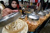 Penjual melayani pembeli kue kering khas lebaran di pusat Kota Lhokseumawe, Provinsi Aceh, Minggu (26/6). Permintaan berbagai jenis kue kering lebaran produksi ibu rumah tangga meningkat mulai dari harga Rp40 ribu-Rp120 ribu perkilogram, harga tersebut naik 15 persen dari harga kue lebaran tahun lalu. (Foto Rahmad)