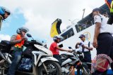 Petugas memeriksa tiket puluhan calon pemudik motor yang akan memasuki kapal KM Kumalal yang akan membawanya ke Surabaya, Senin (27/6). 400 penumpang mulai memadati pelabuhan Trisakti Banjarmasin pada H-9 Idul Fitri 1437 Hijriah. Foto Antaranews Kalsel/Herry Murdy Hermawan