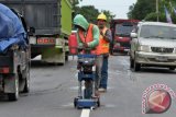 Pekerja menyelesaikan pemasangan kaca mata kucing atau kaca pemantul cahaya pada marka Jalan Lintas Timur Sumatera Jambi-Pekanbaru di Sekernan, Muarojambi, Jambi, Senin (27/6). Pemasangan kaca mata kucing untuk meningkatkan kenyamanan dan keselamatan pengendara menyambut musim mudik tersebut ditargetkan selesai sebelum H-7 Lebaran. ANTARA FOTO/Wahdi Septiawan/pd/16.