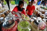 Penjual melayani pembeli kue kering khas lebaran di pusat Kota Lhokseumawe, Provinsi Aceh, Minggu (26/6). Permintaan berbagai jenis kue kering lebaran produksi ibu rumah tangga meningkat mulai dari harga Rp40 ribu-Rp120 ribu perkilogram, harga tersebut naik 15 persen dari harga kue lebaran tahun lalu. ANTARA FOTO/Rahmad/pd/16