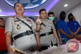 Kapolda Kalbar, Brigjen Pol Musyafak (kiri) memperlihatkan barang bukti narkoba saat gelar hasil ungkap kasus di Mapolda Kalbar, Rabu (29/6). Pada Senin (27/6), Polres Sambas berhasil menggagalkan penyelundupan narkoba berupa 6,4 kilogram sabu dan 38.730 butir pil ekstasi yang akan dilakukan oleh dua tersangka kurir yaitu Ruston Nawawi dan Deni Nurdiansyah dari Malaysia ke Indonesia melalui pintu perbatasan Indonesia-Malaysia di Kecamatan Sajingan, Kabupaten Sambas, Kalbar. ANTARA FOTO/Sheravim/jhw/16