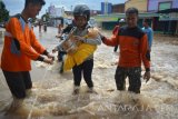 Sejumlah relawan membantu warga saat melewati lokasi banjir jalan pantura kraton, Pasuruan, Jawa Timur, Kamis (30/6). Banjir setinggi 1 meter tersebut terjadi akibat meluapnya Sungai Welang setelah diguyur hujan lebat sejak Rabu (29/6) malam sehingga membuat jalur pantura lumpuh. Antara Jatim/Umarul Faruq/zk/16