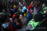 Sejumlah warga mengantre guna memperoleh uang sedekah menjelang Hari Raya Idul Fitri dari salah satu perusahaan rokok di Kota Kediri, Jawa Timur, Jumat (1/7). Sedekah tahunan tersebut merupakan program Corporat Social Responsibility (CSR) yang mendukung target pemerintah menurunkan tingkat kemiskinan hingga 10 persen dari jumlah penduduk Indonesia pada tahun 2016. Antara Jatim/Prasetia Fauzani/zk/16