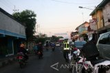 Seorang petugas Polres Lamongan menyeberangkan sejumlah warga di depan jalan raya Pasar Babat, Senin (4/7). Di Jalur jalan raya di depan Pasar Babat, yang biasanya selalu macet, sekarang ini lancar tidak terjadi kemacetan lalu lintas karena memperoleh penjagaan sejumlah petugas. Antara Jatim/Foto/Slamet Agus Sudarmojo/zk/16. 