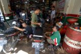 Pekerja menyelesaikan proses ganti oli, di bengkel ganti oli di Pamekasan, Jatim, Senin (4/7). Menjelang idulfitri tahun ini, jasa ganti oli sepeda motor meningkat hingga sekitar 100 persen dan bulan sebelumnya. Antara Jatim/Saiful Bahri/16