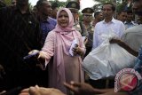 Presiden Joko Widodo (ketiga kanan) mendampingi Ibu Negara Ny Iriana Joko Widodo (tengah) menyerahkan santunan kepada warga kurang mampu di Kampung Ranca Garut, Sangiang Tanjung, Lebak, Banten, Senin (4/7). Presiden Joko Widodo menyalurkan tiga ribu paket sembako dan uang di tiga lokasi dalam rangka Safari Ramadan. ANTARA FOTO/Asep Fathulrahman/wdy/16