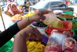 Pedagang menimbang manisan buah di Pasar Petisah, Medan, Sumatera Utara, Minggu (3/7). Manisan buah yang biasa disajikan pada perayaan Lebaran tersebut dijual seharga Rp35.000 - Rp100.000/kg. ANTARA SUMUT/Irsan Mulyadi/16