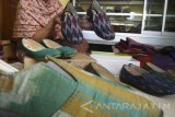 Perajin menata sepatu yang terbuat dari kain tenun perca di sentral industri rumahan tenun kelurahan Bandar Kidul, Kota Kediri, Jawa Timur, Senin (4/7). Perajin memanfaatkan potongan-potongan kain tenun tak terpakai menjadi sepatu yang dijual seharga Rp75.000 - Rp120.00 per pasang tergantung model dan ukuran. Antara Jatim/Prasetia Fauzani/zk/16