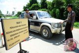 Dua anggota Polsek Entikong kendaraan yang melintasi Mapolsek Entikong di Kabupaten Sanggau, Kalbar, Selasa (5/7). Pasca terjadinya peristiwa bom bunuh diri di Polres Surakarta pada Selasa (5/7), Polsek Entikong memperketat pengamanan dan meningkatkan kewaspadaan serta melakukan pemantauan melalui CCTV yang ditempatkan di beberapa titik di wilayah perbatasan Entikong. ANTARA FOTO/Jessica Helena Wuysang/16