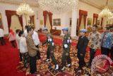 Presiden Joko Widodo (kiri) didampingi Ibu Negara Iriana Joko Widodo (kedua kiri), Wapres Jusuf Kalla (ketiga kiri), Ibu Mufidah Jusuf Kalla (keempat kiri) berjabat tangan dengan Anggota Pasukan Pengamanan Presiden (Paspampres) saat acara silaturahmi Idul Fitri 1437 H dengan Pemimpin Lembaga Negara, Menteri Kabinet Kerja di Istana Negara, Jakarta, Senin (11/7). Dalam silaturahim tersebut hadir pula Pejabat Eselon I Kementerian Sekretariat Negara serta karyawan Kantor Staf Presiden. ANTARA FOTO/Yudhi Mahatma/wdy/16