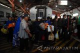 Sejumlah penumpang turun dari gerbong kereta api Maharani dari Semarang tiba di Stasiun Pasar Turi Surabaya, Jawa Timur, Senin (11/7).  Arus balik pemudik pengguna jasa transportasi Kereta Api pada H+4 berjumlah 530.424 penumpang naik satu persen dari tahun 2015 yang berjumlah 524.904 penumpang. Antara Jatim/M Risyal Hidayat/zk/16