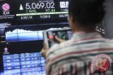 Karyawan mengamati pergerakan Indeks Harga Saham Gabungan (IHSG) di Bursa Efek Indonesia, Jakarta, Senin (11/7/2016). Setelah sepekan libur Lebaran, Indeks Harga Saham Gabungan melesat di hari pertama perdagangan. Indeks ditutup menguat 1,96% menjadi 5.069,02 dengan volume transaksi sebesar 6,09 miliar saham dan nilai transaksi mencapai Rp 9,18 triliun. (Foto Muhammad Adimaja) 