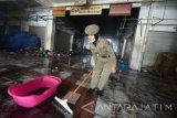 Petugas satpol pp membersihkan bekas kebakaran di Pasar Legi Kota Blitar, Jawa Timur, Rabu (13/7). Pascakebakaran yang menghanguskan sekitar 200 los dan kios di pasar tersebut, sejumlah petugas satpol pp dikerahkan untuk melakukan pembersihan guna mempermudah proses identifikasi oleh polisi. Antara jatim/Irfan Anshori/zk/16