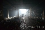 Petugas satpol pp membersihkan bekas kebakaran di Pasar Legi Kota Blitar, Jawa Timur, Rabu (13/7). Pascakebakaran yang menghanguskan sekitar 200 los dan kios di pasar tersebut, sejumlah petugas satpol pp dikerahkan untuk melakukan pembersihan guna mempermudah proses identifikasi oleh polisi. Antara Jatim/Irfan Anshori/zk/16