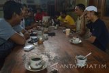 Sejumlah pengunjung berbincang sambil menikmati minuman di sebuah warung kopi di Ponorogo, Jawa Timur, Rabu (13/7). Warung kopi yang juga menyediakan menu makanan tersebut setiap hari dikunjungi ratusan orang, terutama mereka yang membutuhkan waktu panjang untuk nongkrong dan akses internet yang difasilitasi pemilik warung. Antara Jatim/Foto/Siswowidodo/zk/16

