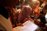 Petugas Dinas Perindustrian dan Perdagangan melakukan inspeksi mendadak harga daging sapi di Pasar Setonobetek, Kota Kediri, Jawa Timur, Jumat (15/7). Sidak di pusat perekonomian rakyat tersebut menemukan data penurunan harga sejumlah kebutuhan pokok paska lebaran seperti daging sapi yang sebelumnya seharga Rp110.000 per kg turun menjadi Rp95.000 per kg. Antara Jatim/Prasetia Fauzani/zk/16