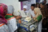 Menteri Sosial Khofifah Indar Parawansa (tengah) Bupati Sidoarjo Saiful Illah (kedua kanan) Wakil Direktur Utama BNI Suprajarto (kanan) melakukan Uji Coba Pembayaran Bantuan Sosial Program Keluarga Harapan (PKH) usai melaunching program e-warung KUBE atau Warung Kelompok Usaha Bersama secara digital di Wonocolo, Taman, Sidoarjo, Jawa Timur, Minggu (17/7). Peresmian e-Warung KUBE tersebut bertujuan untuk mengembangkan Bantuan Sosial Program Keluarga Harapan (PKH) dan memperoleh manfaat atau nilai tambah sebagai Agen BNI46. Antara Jatim/Umarul Faruq/zk/16