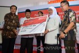 Menteri Sosial Khofifah Indar Parawansa (kedua kanan) Bupati Sidoarjo Saiful Illah (kedua kiri) Wakil Direktur Utama BNI Suprajarto (kiri) secara simbolis menerima Bantuan Sosial Program Keluarga Harapan (PKH) usai melaunching program e-warung KUBE atau Warung Kelompok Usaha Bersama secara digital di Wonocolo, Taman, Sidoarjo, Jawa Timur, Minggu (17/7). Peresmian e-Warung KUBE tersebut bertujuan untuk mengembangkan Bantuan Sosial Program Keluarga Harapan (PKH) dan memperoleh manfaat atau nilai tambah sebagai Agen BNI46. Antara Jatim/Umarul Faruq/zk/16