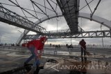 Sejumlah petugas kebersihan membersihkan area Jembatan Suroboyo di Surabaya, Jawa Timur, Senin (18/7). Jembatan dengan panjang sekitar 800 meter dan menghabiskan anggaran Rp200 miliar tersebut merupakan salah satu ikon  baru pariwisata di Surabaya dan termasuk dalam daftar 10 jembatan terbaik di dunia. Antara Jatim/Moch Asim/zk/16