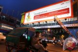 Seorang pria duduk dibecak bermotor menggunakan telpon seluler dengan latar belakang papan iklan Telkomsel, di Medan, Sumatera Utara. Layanan komunikasi yang cepat dengan kekuatan sinyal, sangat membantu warga dalam berkomunikasi. ANTARA SUMUT/Irsan Mulyadi/16