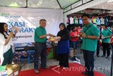 Kepala BPJS Ketenagakerjaan Kediri  Wahyudi Purwanto memberikan brosur tentang BPJS Ketenagakerjaan di Pasar Pahing, Kota Kediri, Jawa Timur, Jumat (22/7). BPJS Ketenagakerjaan menargetkan penambahan peserta baru bukan penerima upah ditahun 2016 menjadi 15.000 peserta. Antara Jatim/Foto/Asmaul Chusna/zk/16 