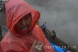 Wisatawan berusaha melindungi wajahnya dari guguran abu vulkanis di bibir kawah Gunung Bromo, Probolinggo, Jawa Timur, Kamis (21/7). Selama dua minggu terakhir, aktivitas Gunung Bromo mengalami peningkatan dengan diikuti peningkatan volume dan lontaran abu vulkanis dari kawah. Antara Jatim/Foto/Siswowidodo/zk/16