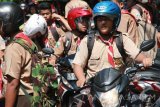 Sejumlah pelajar SMP mengendarai sepeda motor keluar halaman SMPN 1 Munjungan, Trenggalek, Jawa Timur, Sabtu (23/7). Menurut data dinas pendidikan setempat, hampir 70 persen siswa SD dan SMP di kawasan pegunungan atau daerah terpencil menggunakan/mengendarai sepeda motor ke sekolah karena alasan jarak rumah ke sekolah yang jauh, medan tempuh yang berat/sulit sementara mayoritas orang tua bekerja di hutan dan ladang. Antara Jatim/Destyan Sujarwoko/zk/16