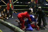 Dua orang wasit melerai pesilat saat memimpin kegiatan Pencak Dor di Desa Duwet, Kabupaten Kediri, Jawa Timur, Sabtu (23/7) malam. Tradisi tarung bebas antar perguruan silat tersebut dalam rangka halal bihalal bulan syawal guna mempererat tali persahabatan. ANTARA FOTO/Prasetia Fauzani/16