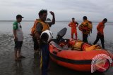 Tim Basarnas Banda Aceh mengevakuasi korban selamat kapal tenggelam, Rajali (memegang helm)  saat tiba di pantai Ujung Pancu, Kabupaten Aceh Besar, Aceh, Minggu (24/7). Basarnas Banda Aceh berhasil mengevakuasi seorang dari tiga nelayan yang selamat setelah kapal motor mereka tenggelam di perairan Pulau Aceh, Aceh, sementara dua nelayan selamat lainnya memilih bertahan di Pulau Aceh  menunggu bantuan untuk menarik kapal mereka yang tenggelam ke daratan. ANTARA Aceh/Ampelsa/16
