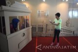 Pengunjung berfoto disalah satu karya seni berbahan kardus dalam pameran 'Subcreation' di Balai Pemuda Surabaya, Jawa Timur, Senin (25/7). Pameran yang berkonsep ornamen dan dekoarasi hasil kerjasama dari Angger Wiranata dan Genie Anggita yang memamerkan sejarah kota Surabaya tersebut dalam rangka menyemarakan konferensi Preparatory Committee (PrepCom) 3 for Habitat III. Antara Jatim/M Risyal Hidayat/zk/16