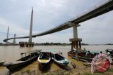 Pekerja bongkar muat barang milik penumpang perahu kayu mesin (ketek) di tepian sungai Batanghari, Jambi, Senin (25/7). Perahu-perahu tradisonal di sungai Batanghari masih menjadi sarana transportasi penyeberangan antar daerah sekaligus jalur niaga hasil bumi serta keperluan rumah tangga meski sarana perhubungan darat sudah tersedia. ANTARA FOTO/Irwansyah Putra/pd/16.