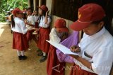 Siti Faisah (kanan) mencatat penjualan makanan ringan yang dijual di SDN Cobbuk Desa Curah Tatal, Arjasa, Situbondo, Jawa Timur, Selasa (26/7). Siti Faisah merupakan siswa SDN Cobbuk yang berjualan makanan ringan untuk dijual ke sesama teman sekolahnya untuk  biaya sekolah karena orang tuanya seorang buruh tani dengan penghasilan tidak tetap di desa itu. Antara Jatim/Seno/zk/16.