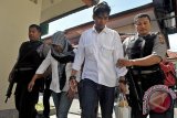 Polisi mengawal pasangan suami istri terpidana mati, Heru Hendriyanto (kedua kanan) dan Putu Anita Sukra Dewi (kedua kiri) saat mengajukan permohonan peninjauan kembali (PK) di Pengadilan Negeri Denpasar, Jumat (29/7). Pasangan suami istri tersebut sebelumnya divonis hukuman mati oleh Pengadilan Negeri Denpasar hingga di tingkat Mahkamah Agung karena kasus pembunuhan berencana terhadap satu keluarga di Bali tahun 2012. ANTARA FOTO/Nyoman Budhiana/i018/2016.