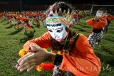 Sejumlah pelajar beserta guru memperagakan Tari Topeng Seribu Panji di stadion Brawijaya, Kota Kediri, Jawa Timur, Kamis (28/7) malam. Sedikitnya seribu orang menari secara kolosal guna  memperingati hari jadi Kota Kediri ke-1137. Antara Jatim/Prasetia Fauzani/zk/16