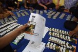 Sejumlah petugas Sistem Komputerisasi Haji Terpadu (Siskohat)  menyortir paspor dan visa calon jamaah haji (CJH) di Asrama Haji Embarkasi Surabaya (AHES), Sukolilo Surabaya, Jawa Timur, Jumat (29/7). Sebanyak 64 kloter berjumlah 28 ribu CJH keberangkatan embarkasi Surabaya. Antara Jatim/M Risyal Hidayat/zk/16