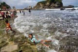 Wisatawan bermain air di tepi Pantai Klayar, Pacitan, Jawa Timur, Minggu (31/7). Pantai Klayar merupakan salah satu destinasi wisata unggulan daerah tersebut yang banyak dikunjungi wisatawan domestik maupun mancanegara dengan omzet PAD (pendapatan asli daerah) dengan target Rp2,5 miliar pada 2016. Antara jatim/Destyan Sujarwoko/zk/16